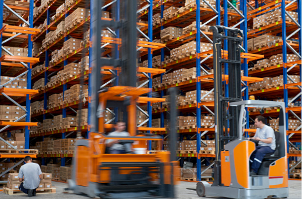 forklifts-carrying-cardboard-box-in-warehouse